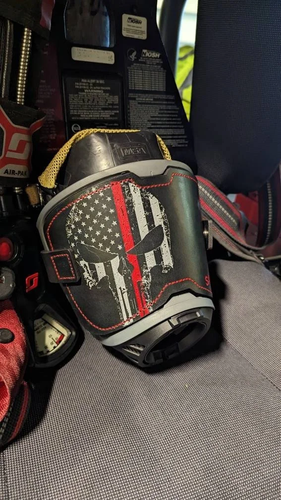 Black leather MSA G1 SCBA mask cover with red stitching and custom firefighter engraving